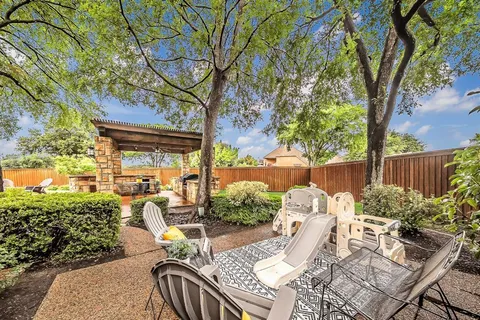 a view of a patio with table and chairs and potted plants