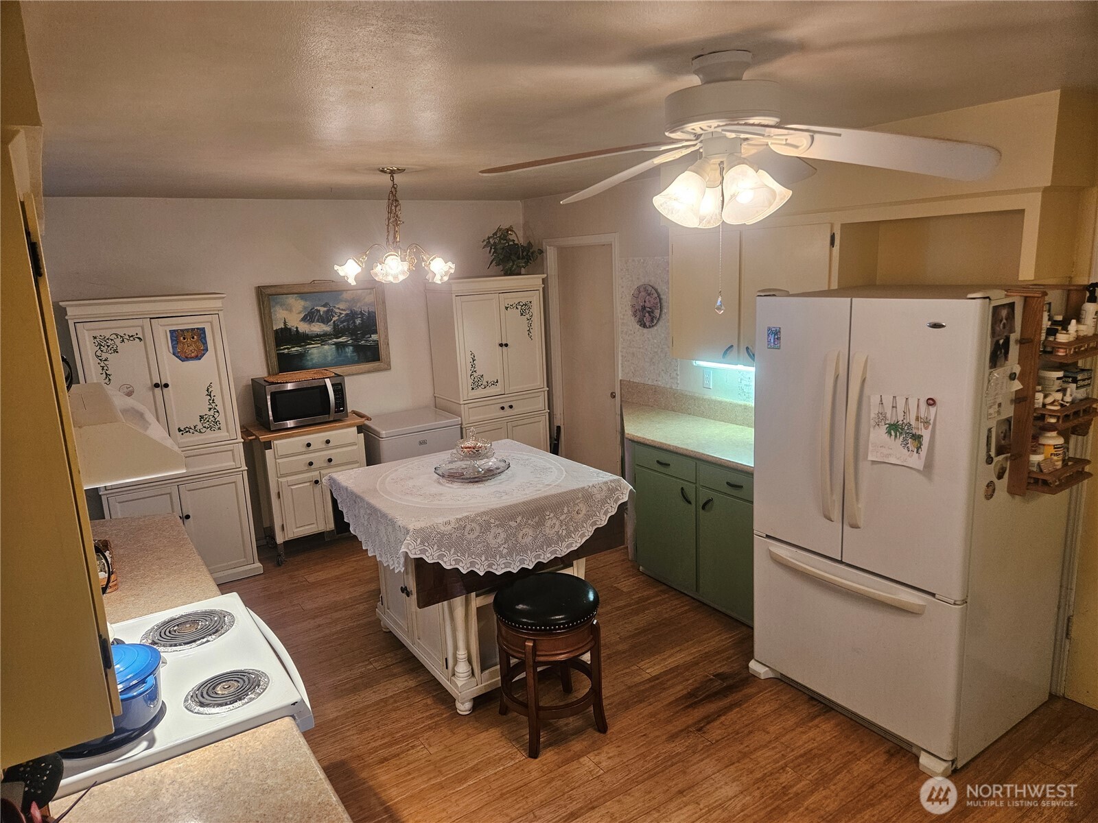 1535 Broad Street Mount Vernon, WA 98274 - Photo 11 of 17 a kitchen with a refrigerator a sink dishwasher a dining table and chairs with wooden floor