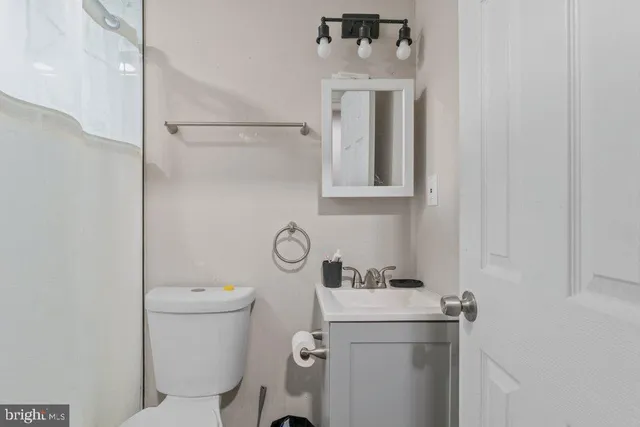 a bathroom with a toilet sink and mirror