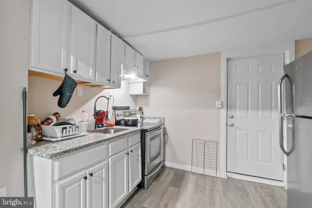 a kitchen with white cabinets and white appliances
