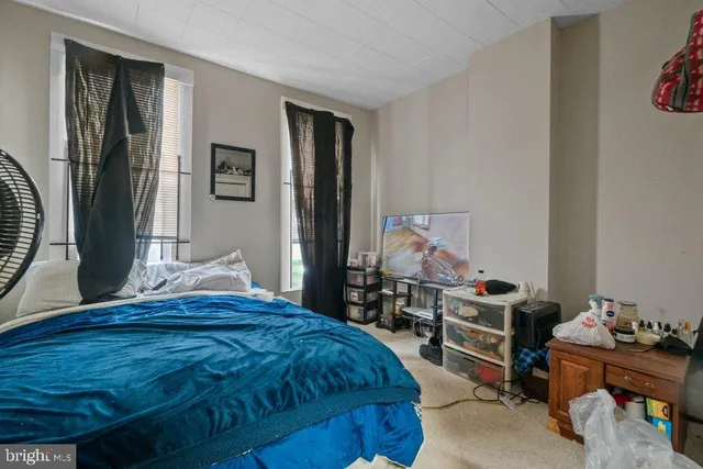 a bedroom with a bed and large windows