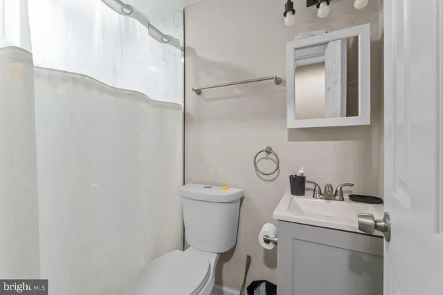 a bathroom with a sink a toilet and shower curtain