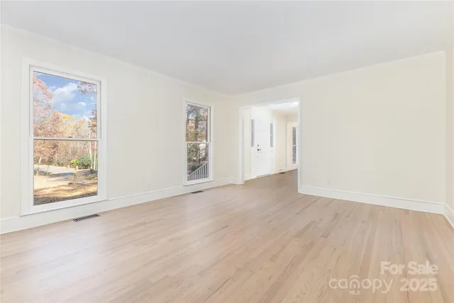 a view of an empty room with a window and a ceiling fan