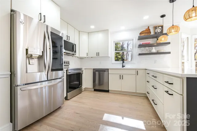 a kitchen with white cabinets and stainless steel appliances
