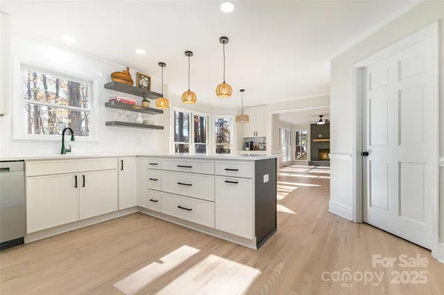 a kitchen with kitchen island granite countertop a sink a counter space stainless steel appliances and cabinets