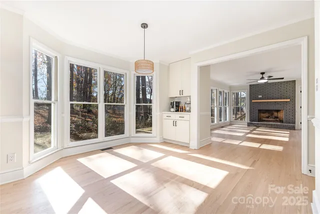 a view of an empty room with window and wooden floor