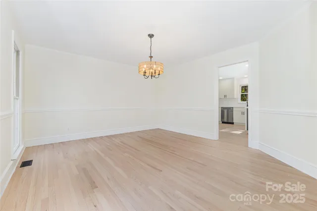 an empty room with an entryway and fan