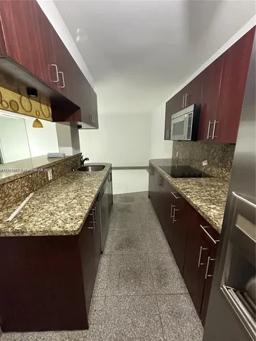 a kitchen with stainless steel appliances granite countertop a stove a sink and a microwave