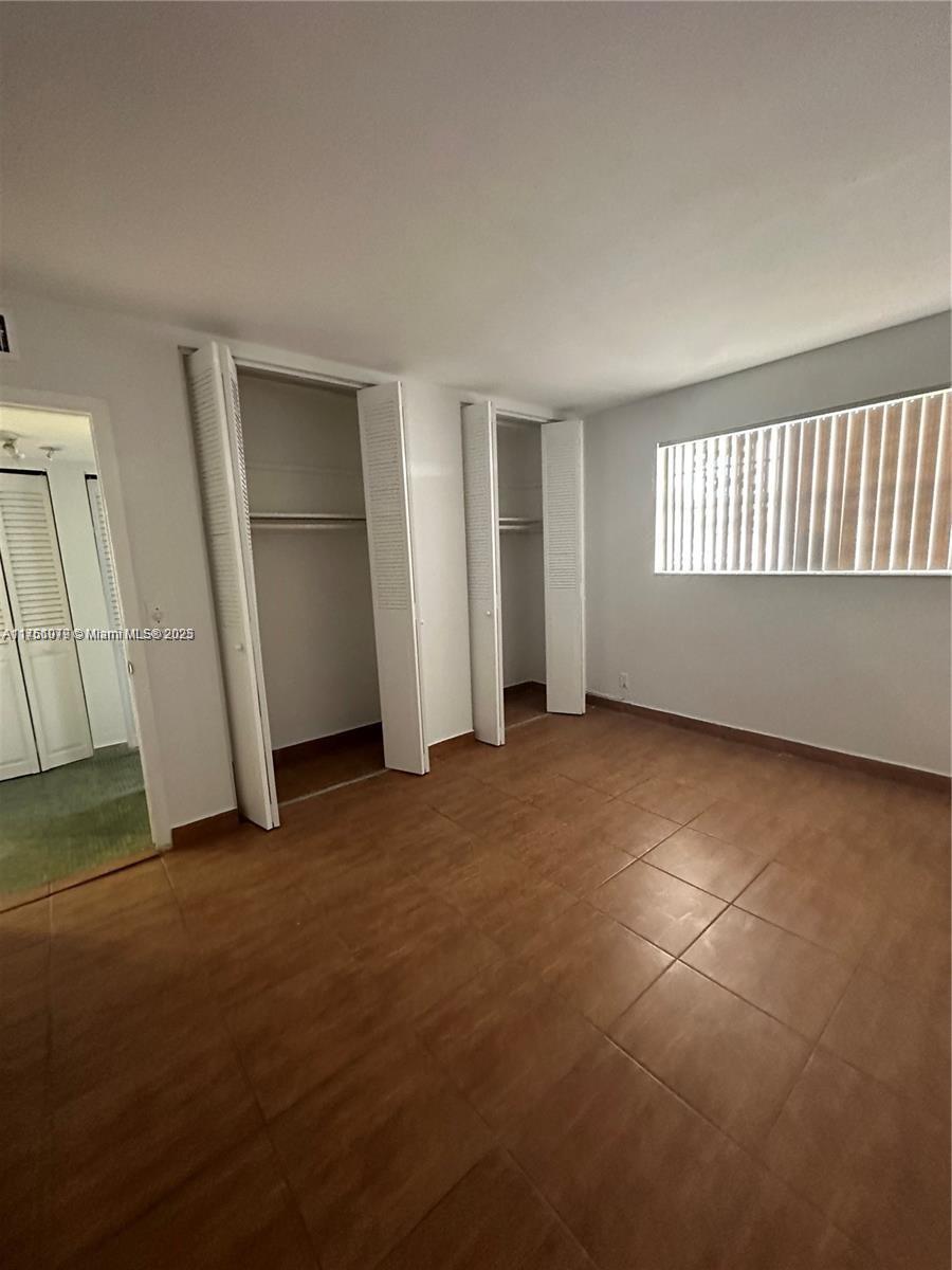 1100 Northeast 1st Court, Unit 105 Hallandale Beach, FL 33009 - Photo 3 of 13 an empty room with windows