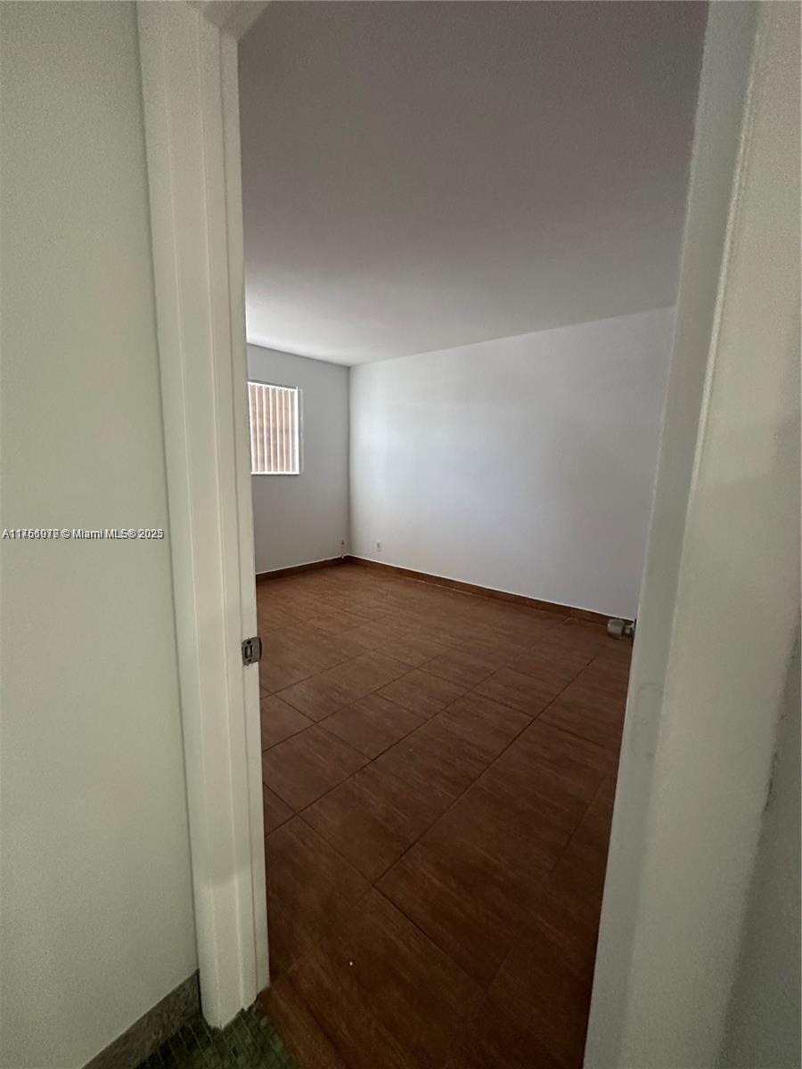 1100 Northeast 1st Court, Unit 105 Hallandale Beach, FL 33009 - Photo 7 of 13 an empty room with windows