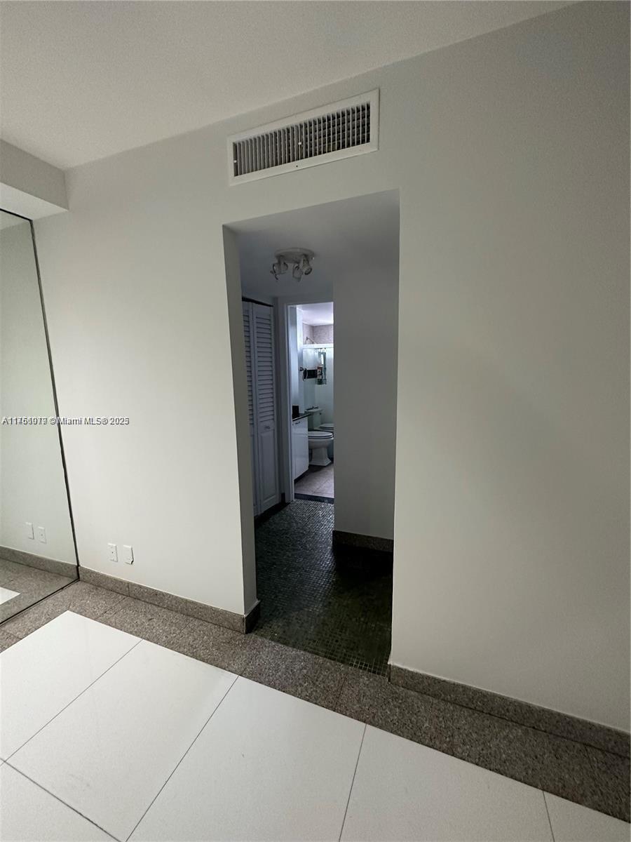 1100 Northeast 1st Court, Unit 105 Hallandale Beach, FL 33009 - Photo 8 of 13 a view of a hallway with wooden floor and a living room