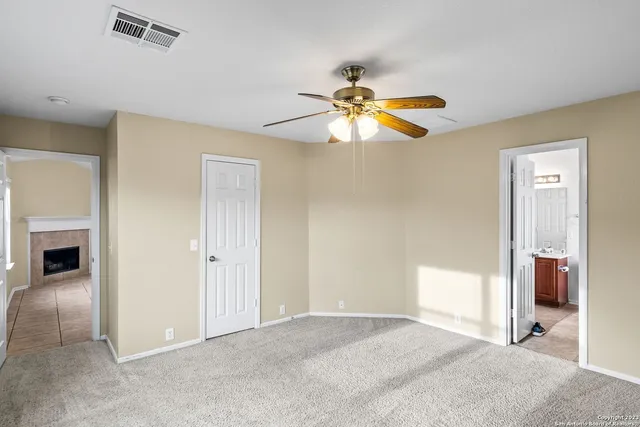 a view of a bedroom with a ceiling fan and a ceiling fan