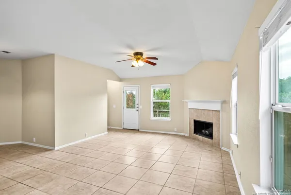 a view of an empty room with a window and fire place
