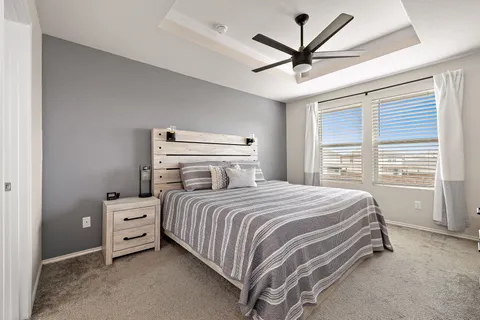 a bedroom with a bed and a ceiling fan