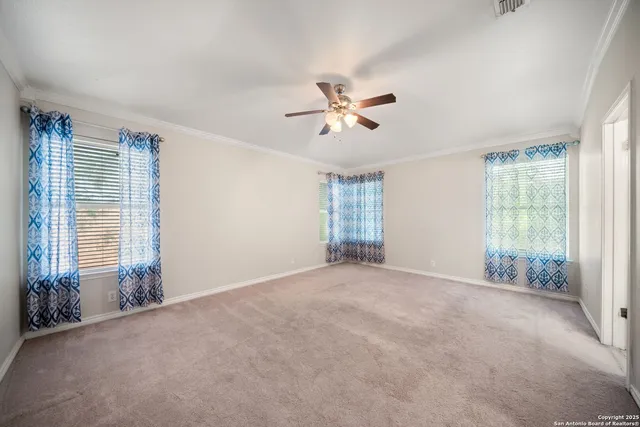 a view of a big room with windows and chandelier fan