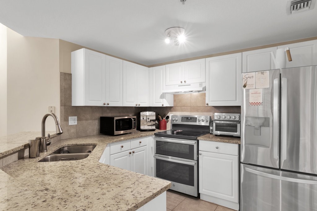 5095 Fairways Circle, Unit I201 Vero Beach, FL 32967 - Photo 8 of 36 a kitchen with stainless steel appliances granite countertop a refrigerator sink and stove