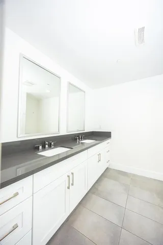 a large bathroom with a double vanity sink and a mirror