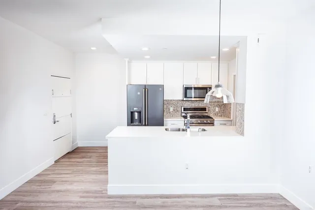 a kitchen with stainless steel appliances a refrigerator and a stove top oven