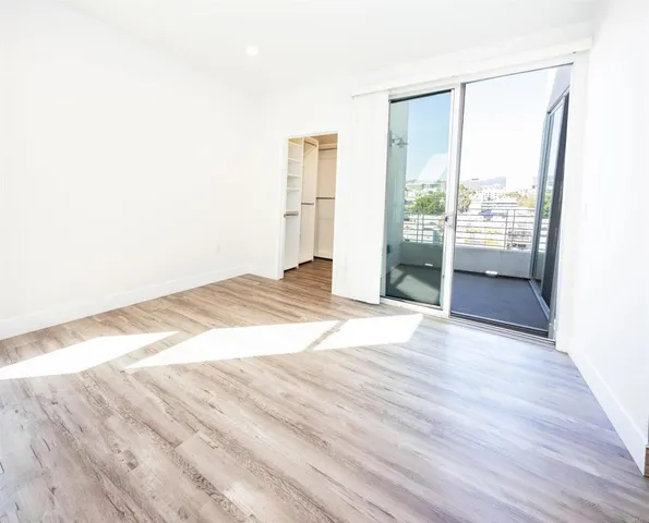 an empty room with wooden floor and sliding door