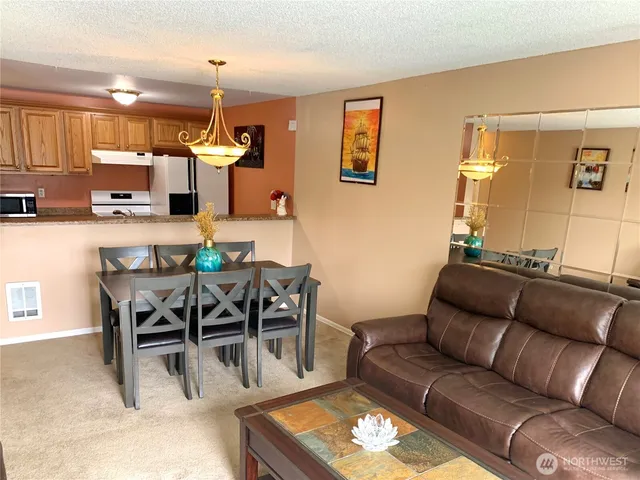 a living room with furniture a kitchen view and a dining table