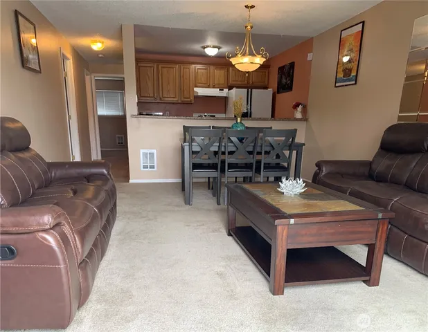 a living room with furniture and a dining table