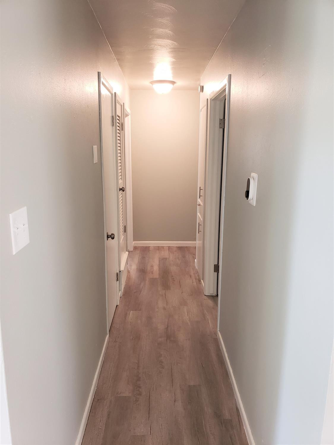 4906 6th Street Lubbock, TX 79416 - Photo 7 of 24 a view of a hallway with wooden floor and a bathroom