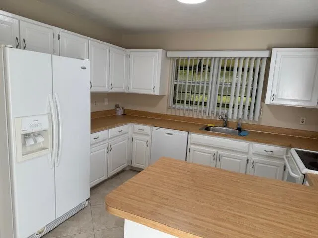 a kitchen with a refrigerator sink and cabinets