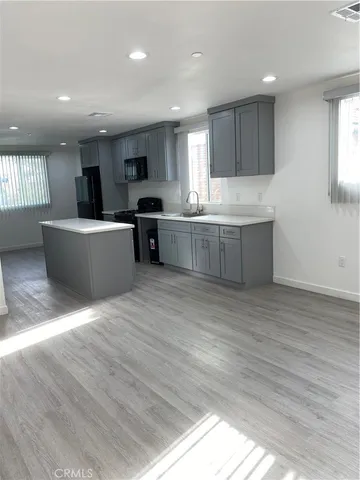 a large kitchen with kitchen island a sink a center island and a window