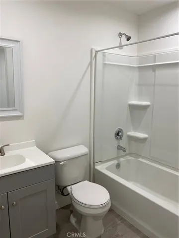 a white toilet sitting next to a bath tub