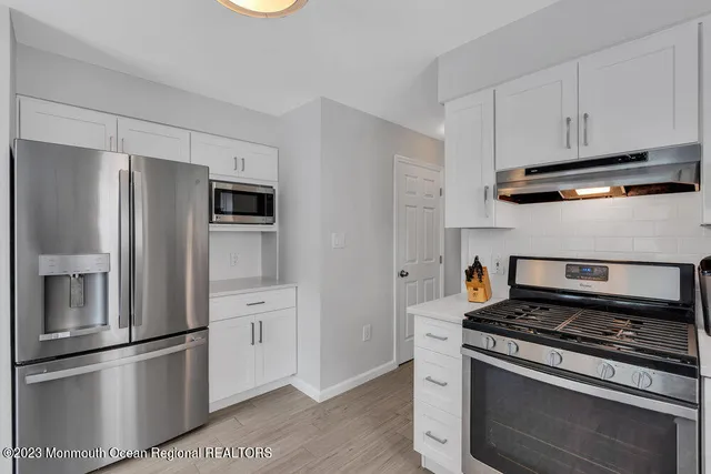 a kitchen with stainless steel appliances and white cabinets