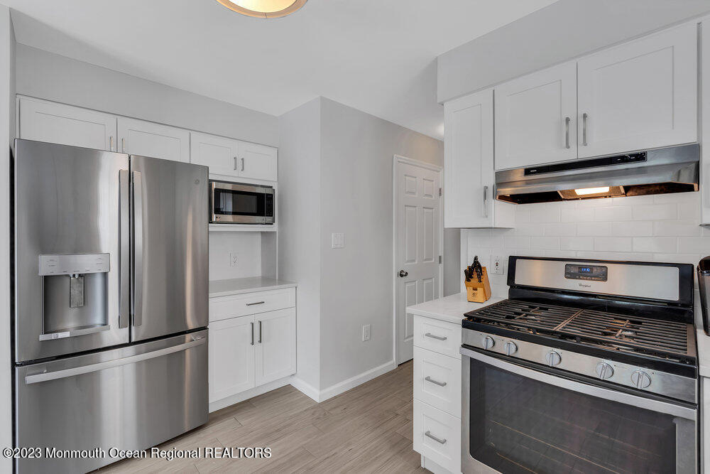 303 Salem Avenue Spring Lake, NJ 07762 - Photo 14 of 38 a kitchen with stainless steel appliances and white cabinets
