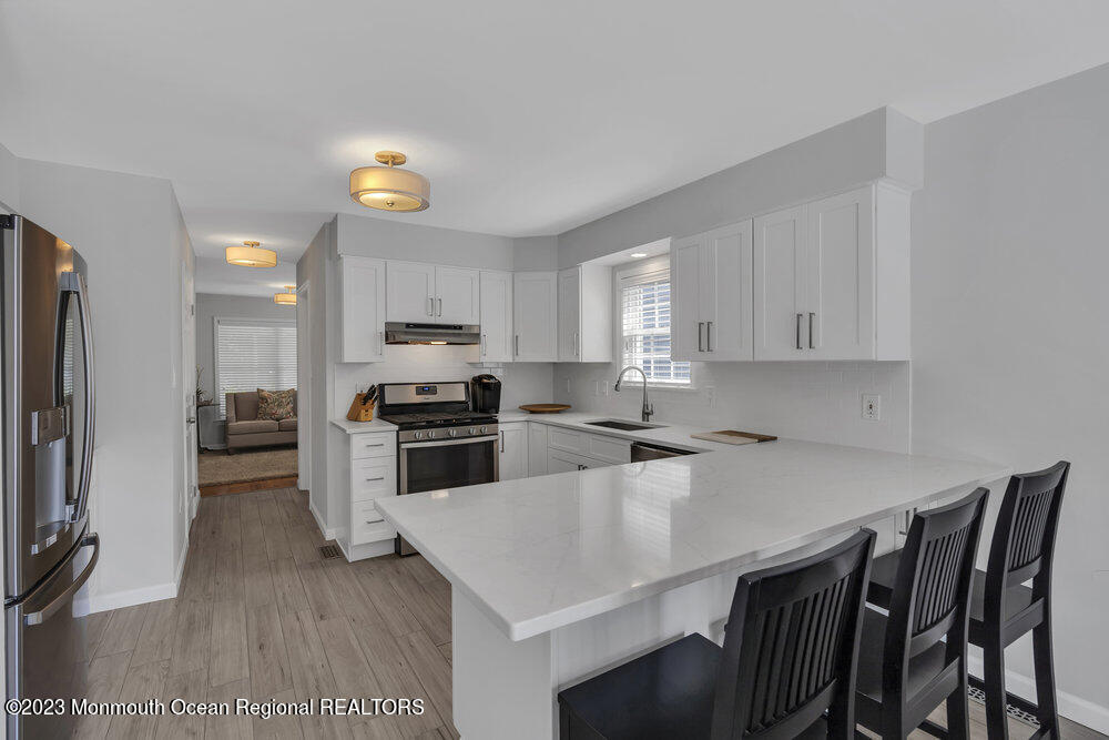 303 Salem Avenue Spring Lake, NJ 07762 - Photo 17 of 38 a kitchen with a table chairs microwave and refrigerator