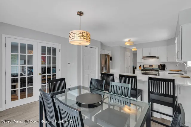 a dining room with furniture a chandelier and wooden floor