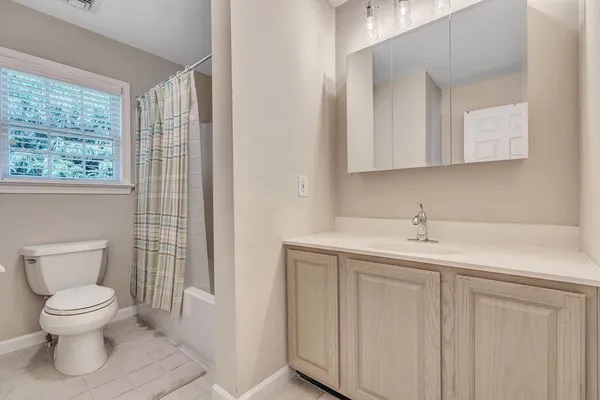 a bathroom with a toilet a sink and a window