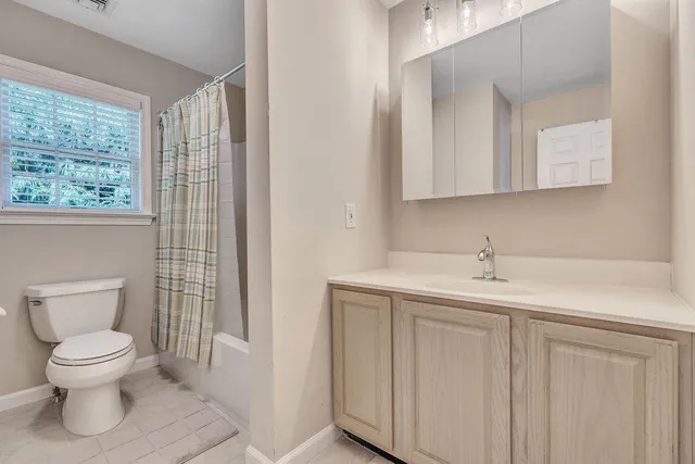 a bathroom with a toilet a sink and a window