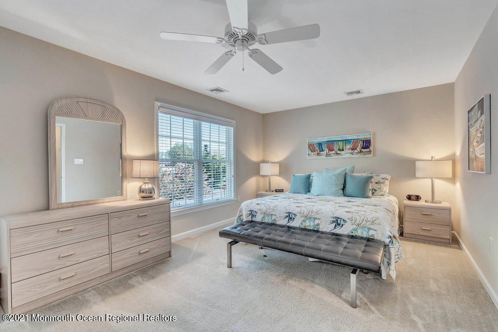 303 Salem Avenue Spring Lake, NJ 07762 - Photo 27 of 38 a bedroom with a large bed and a chandelier