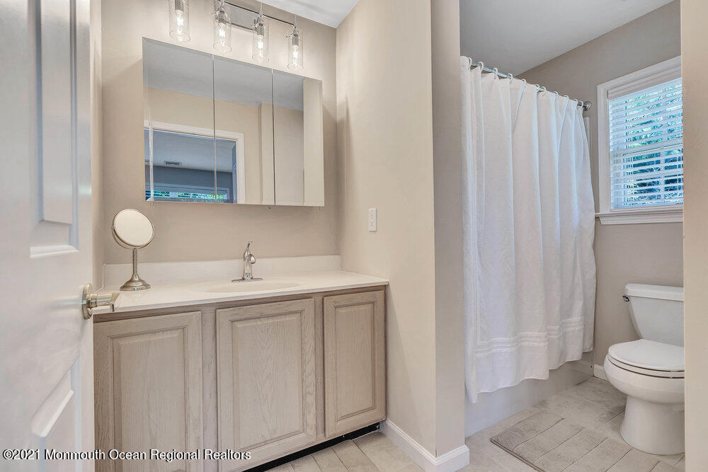 303 Salem Avenue Spring Lake, NJ 07762 - Photo 30 of 38 a bathroom with a toilet a sink and mirror