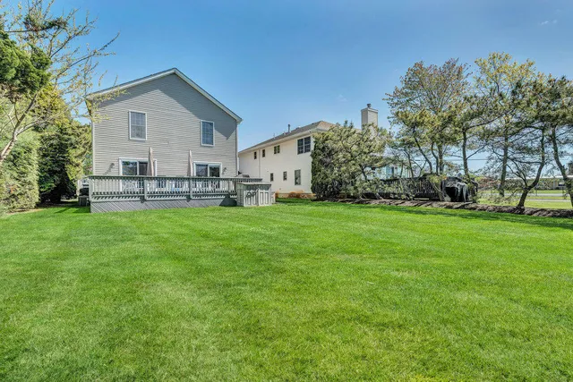 a front view of a house with a yard and trees