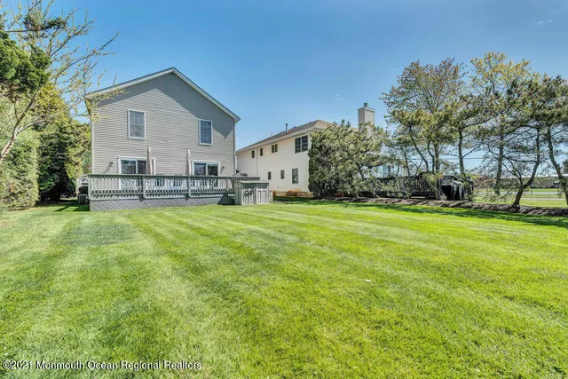 a view of a house with a big yard and large trees