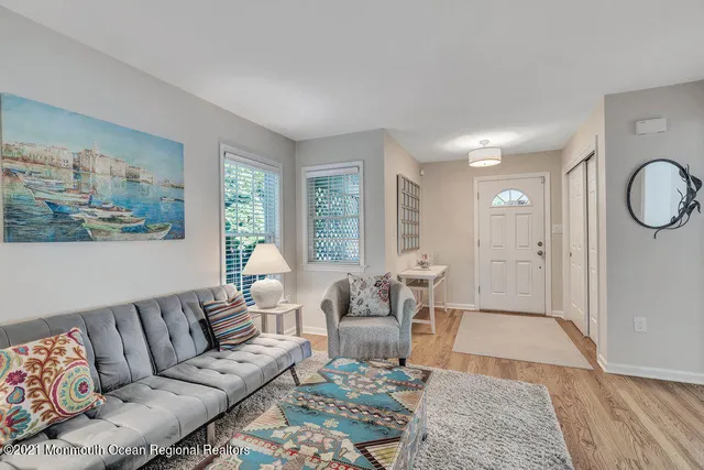 a living room with furniture wooden floor and a large window