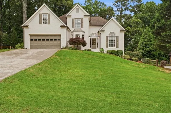 a view of house with garden and tall trees