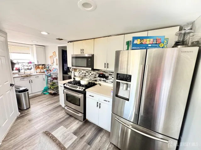 a kitchen with stainless steel appliances a refrigerator sink and microwave
