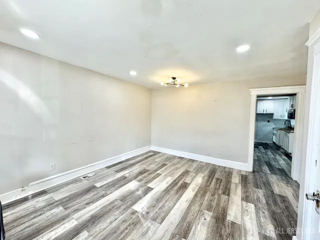 a view of a kitchen with wooden floor a sink a refrigerator and window