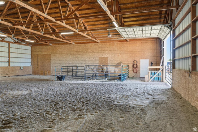 1634 West Arimo Road Arimo, ID 83214 - Photo 39 of 89 Spacious indoor arena with sand footing, exposed wood beam ceiling, ample fluorescent lighting, and large overhead door entry
