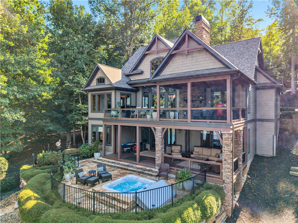 256 Talton Road Six Mile, SC 29682 - Photo 7 of 50 Multi-level outdoor decking and stone patios surround a built-in spa with wooded backdrops.