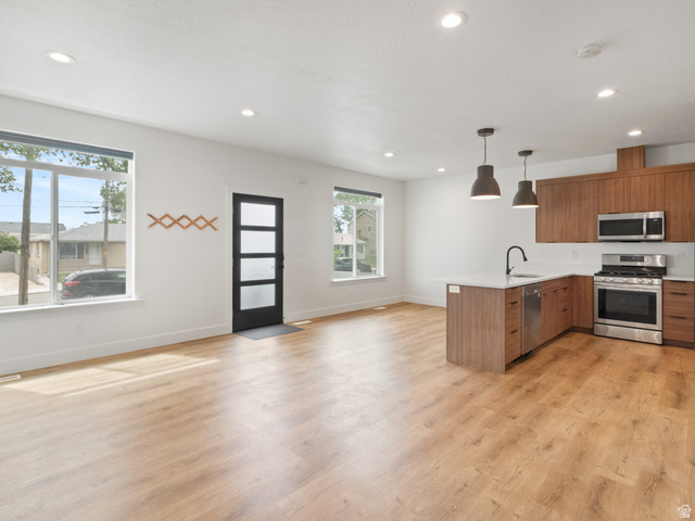 130 East 7085th South, Unit 3 Midvale, UT 84047 - Photo 29 of 30 Kitchen featuring pendant lighting, open floor plan, stainless steel appliances, wood finish cabinetry, and a peninsula