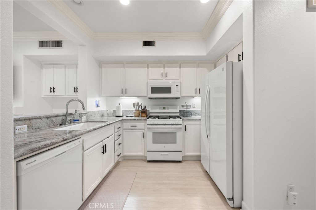 6 Lynde Street Ladera Ranch, CA 92694 - Photo 20 of 35 a kitchen with granite countertop white cabinets and white appliances