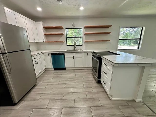 a view of an empty room with wooden floor and a bathroom