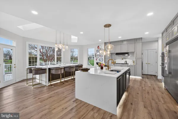 a large kitchen with stainless steel appliances a refrigerator and a stove top oven