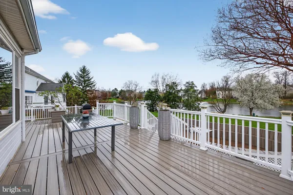 a view of a patio with dining table and chairs with wooden floor and fence